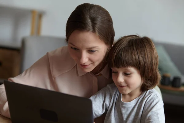 Máma a syn pomocí notebooku spolu, surfování na internetu, nakupování, a hraní her. — Stock fotografie