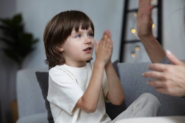 Mutlu anne ve oğul el çırpıyor. Aile dostluğu. Hafta sonu evde.