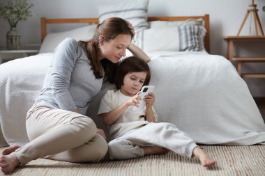 Kendine güveni tam bir anne, küçük oğlu internet üzerinden akıllı telefon sörfü yapıyor.
