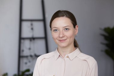 Güzel, genç, esmer bir kadının yakından çekilmiş portresi. Doğal güzellik. Mavi gözler evde gülümsüyor.