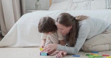 Kendine güvenen anne ve oğlu birlikte oynayarak renkli tuğlalar inşa ediyorlar. Hafta sonunun keyfini çıkarıyorlar.