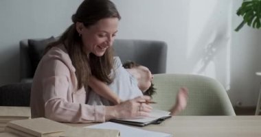 Sevimli, gülümseyen bir çocuk etrafta oynaşıyor ve eğleniyor, anne öğrenmekte zorlanıyor.