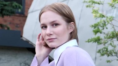 Kısa saçlı genç bayan öğrenci hafif rüzgarla el salladı.