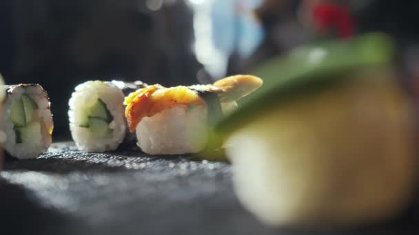 Fechar-se de rolos de sushi saborosos cheios de salmão cru de abacate, enguia. Variedade de tipos sushi com peixe, verduras e arroz. Restaurante Sushi, entrega de comida. Foco seletivo — Vídeo de Stock