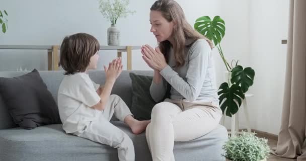 Female parent playing with male kid clapping hands at home. Happy woman spending time with son — Stock Video