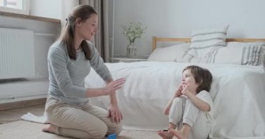 Mutlu anne ve oğul el çırpıyor. Aile dostluğu. Hafta sonu evde.