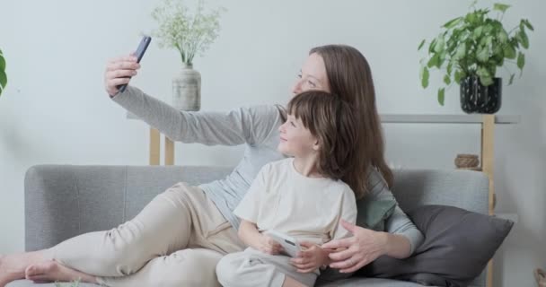 Современная женщина-няня и мальчик-ребенок позируют обнимаясь друг с другом, делая фото с помощью смартфона — стоковое видео