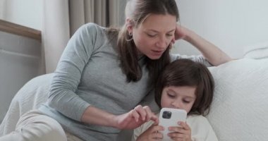 Kendine güveni tam bir anne, küçük oğlu internet üzerinden akıllı telefon sörfü yapıyor.