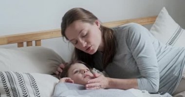 Kadın dadı baş ağrısı belirtileri sırasında erkek çocuğun kafasına dokunmasıyla ilgileniyor.