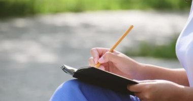 Kapalı siyah tenli kadın elleri not defterine kağıt notlar yazarken kalem kullan