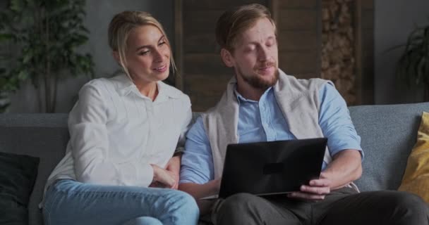 时尚情侣商业伙伴携手合作，在舒适的公寓里使用笔记本电脑上网搜索 — 图库视频影像