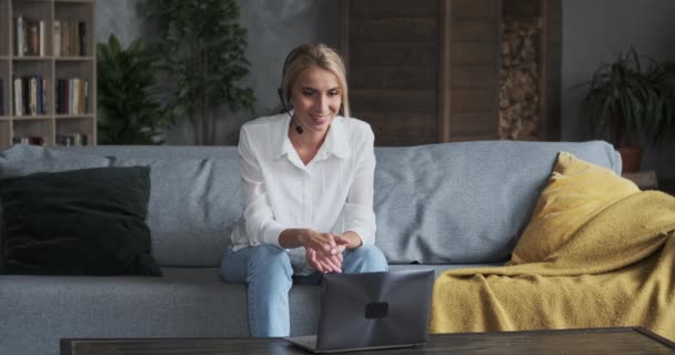 Mujer feliz en auriculares mirando a la cámara, disfrutando de la reunión de vídeo con amigos y colegas — Vídeos de Stock