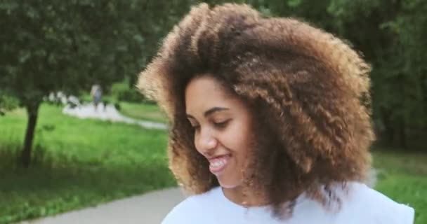 Närbild porträtt överlycklig mörk hud kvinna bär trådlösa hörlurar skrattar positiva känslor — Stockvideo