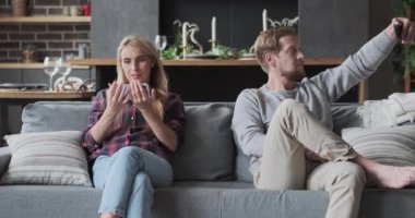 Modern koca eşi rahatlıyor. Poz veriyor, fotoğraf çekiyor. Akıllı telefondan eğlence videoları seyrediyor.