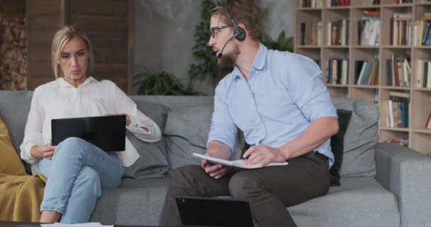 Moderno hombre de negocios y mujer freelancer trabajando juntos utilizar el ordenador portátil y auriculares en la oficina en casa — Vídeos de Stock