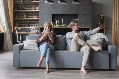 Modern koca eşi rahatlıyor. Poz veriyor, fotoğraf çekiyor. Akıllı telefondan eğlence videoları seyrediyor.