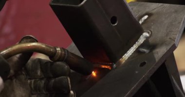 Üniformalı, koruyucu elbiseli, kasklı, eldivenli metal kaynaklı parlayan ışıklar.