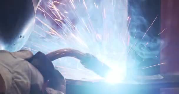Samec svářečka v uniformních ochranných oděvech, přilba, rukavice svařování kovové části osvětlená svítidla — Stock video