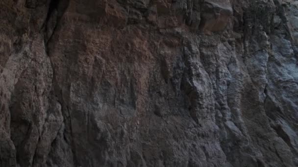 Túnel rocoso marrón gris del acantilado sobre el agua de mar en día soleado — Vídeos de Stock