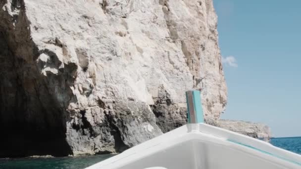 Arc de bateau à moteur blanc vogue le long de la mer bleue près de grandes falaises — Video