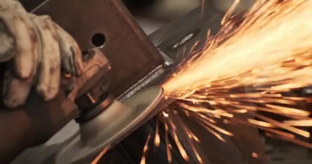 Professional male hands in protective gloves master of welding seams working at angle grinder — Stockvideo