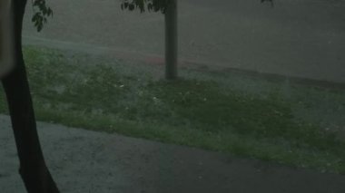 Yağmurlu bir gecede ıslanan boş şehir sokağında su birikintileri, asfalt yolda kabarcıklar...