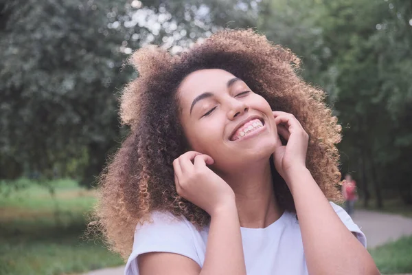 stock image Close up portrait overjoyed dark skin woman wearing wireless earphones laughing positive emotion