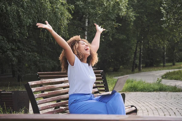 Mulher negra feliz excitado está ativamente se alegrando ganhar a loteria on-line, aprovação de hipoteca e testes médicos. Imagem De Stock