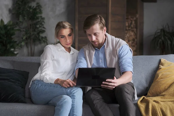 Trendy couple business partner working together use laptop at cozy apartment browsing web searching Stock Photo