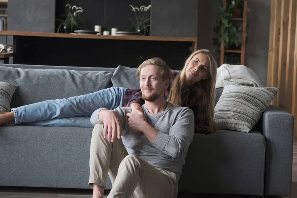 Smiling marriage couple enjoying weekend leisure activity lying on couch together at home Stock Image
