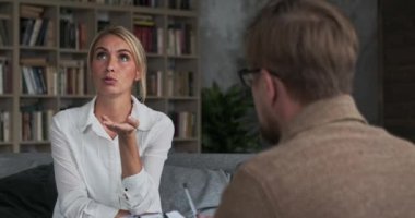 Profesyonel erkek doktor, düşünceli kadın hastayı dinleyip akıl sağlığını tartışıyor.