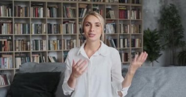 Gülümseyen Avrupalı bayan uzaktan çalışan meslektaşlarına ya da arkadaşlarına video konferansı çağrısında bulundu