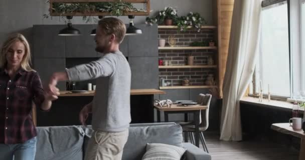 Vrolijk modern huwelijk koppel dansen samen glimlachend knuffelen elkaar in gezellig huis — Stockvideo