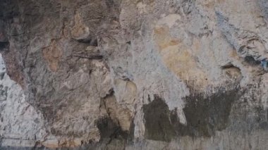 Gri kahverengi kayalık uçurum tüneli güneşli bir günde deniz suyunun üzerinde