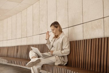 Parktaki bir dizüstü bilgisayarda çalışan genç bir kadın. İnternet üzerinden uzaktan kumanda konsepti. Parkta serbest çalışan biri.