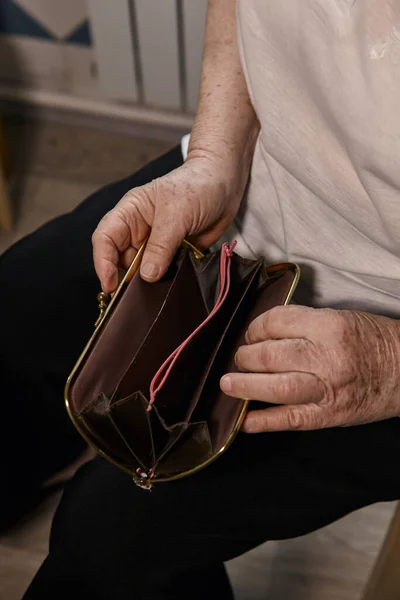 Yaşlı kadın parayı sayıyor. Yaşlı, beyaz, yaşlı, beyaz saçlı bir kadın çantasından para alıp sayıyor. Yaşlı eller faturaları tutar. 