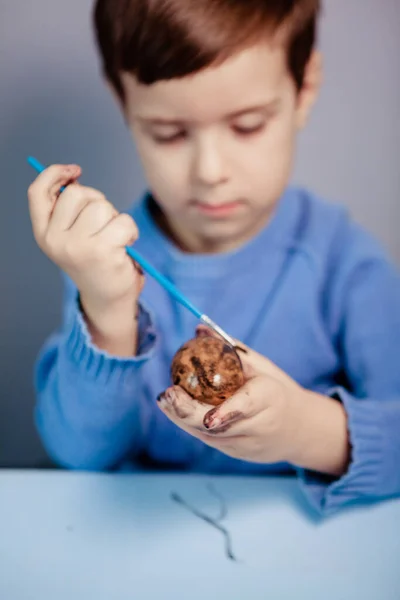 Niño Pequeño Pinta Huevo Pascua Mesa Sobre Fondo Azul Little —  Fotos de Stock