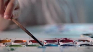 Bir çocuk odasındaki bir masada resim çizer..