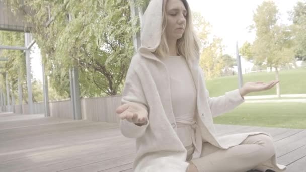 Uma mulher medita no parque — Vídeo de Stock