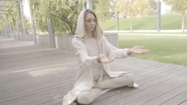 Bir kadın parkta meditasyon yapıyor.