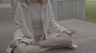 Bir kadın parkta meditasyon yapıyor.