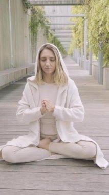 Bir kadın parkta meditasyon yapıyor.