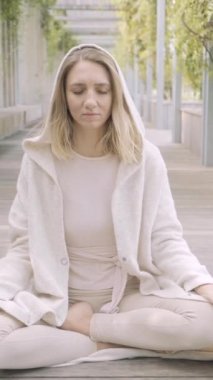 Bir kadın parkta meditasyon yapıyor.