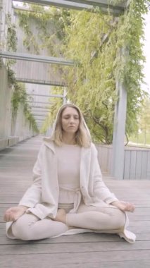 Bir kadın parkta meditasyon yapıyor.