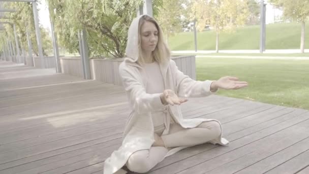 En kvinna mediterar i parken — Stockvideo