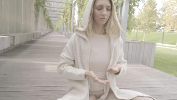 Kobieta medytuje w parku. — Wideo stockowe