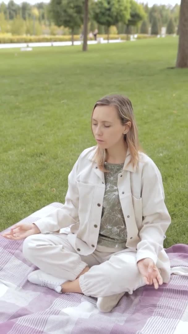 Молодая женщина сидит и медитирует в лотосе — стоковое видео