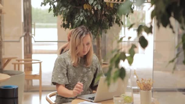 Mulher sentada à mesa com laptop no café — Vídeo de Stock