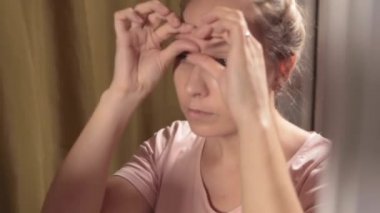 Aynanın önünde kendine masaj, sağlık ve sağlıklı cilt bakımı konsepti..