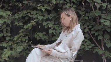 Park yerinde dizüstü bilgisayarlı bir kadın oturuyor. 